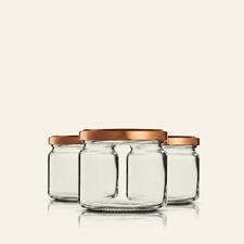 Drei hohe Einmachgläser mit goldenen Deckeln
