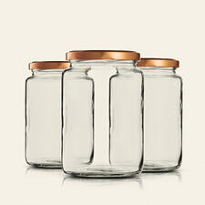 Drei hohe Einmachgläser mit goldenen Deckeln