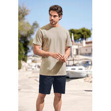 Sand Mann im beigen T-Shirt und blauen Shorts steht am Hafen.