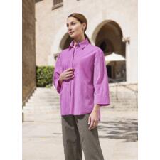 Streifenbluse 2.0 Frau in pink gestreifter Bluse steht vor historischem Hintergrund.