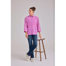 Streifenbluse 2.0 Rosa Streifenbluse 2.0, locker geschnitten, Modell steht an einem Hocker.