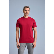 Rot Mann trägt rotes T-Shirt mit Rundhalsausschnitt, poses vor grauem Hintergrund.