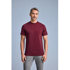 Dunkelrot Mann trägt burdeos rotes T-Shirt mit Rundhalsausschnitt, poses vor grauem Hintergrund.