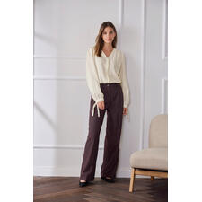 Baumwoll-Kaschmir-Crinkle-Bluse Frau steht in einer hellen Baumwoll-Kaschmir-Bluse mit langen Ärmeln.