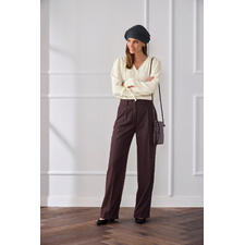 Baumwoll-Kaschmir-Crinkle-Bluse Frau in heller Baumwoll-Kaschmir-Bluse und braunen Hosen, mit Kopftuch.