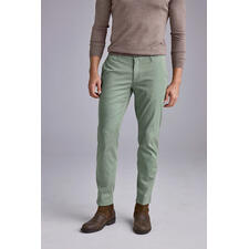 Avocado Mann in hellgrünen Chinos mit braunen Schuhen steht auf grauem Hintergrund.