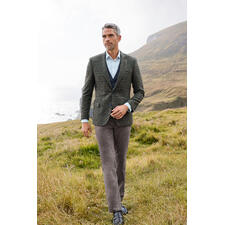 Schwarz Mann im Donegal-Sakko auf einer Wiese am Meer