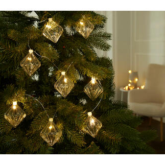 Lichterkette mit gläsernen Ornamenten am Weihnachtsbaum.