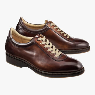 Zwei Cordwainer Edelsneaker in Braun auf hellem Hintergrund.