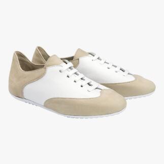 Beige und weiße Komfort-Sneaker auf einem neutralen Hintergrund, frontal betrachtet.