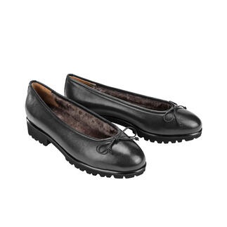 Zwei schwarz Lammfell-Ballerinas nebeneinander auf hellem Hintergrund.