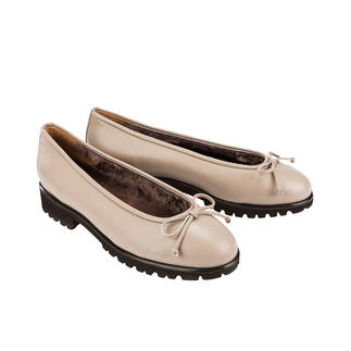 Zwei beige Lammfell-Ballerinas nebeneinander auf hellem Hintergrund.