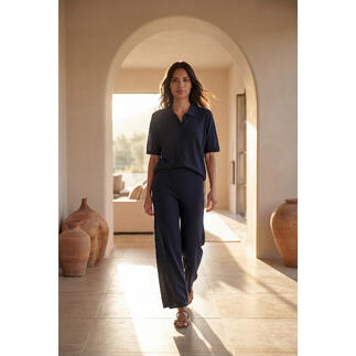 Tencel-Seiden-Strickbluse in navy, elegant mit weit geschnittenen Beinen in einem stilvollen Raum.