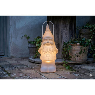 LED-Gartenzwerg mit sanftem Licht, platziert auf einem Ziegelsteinboden neben Pflanzentöpfen.