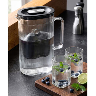 Wasserfilter-Karaffe mit zusätzlichem Glas und frischen Kräutern.