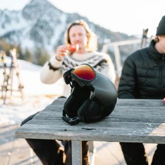 Hybrid-Visierhelm auf einem Tisch mit einer Getränkeflasche im Hintergrund.