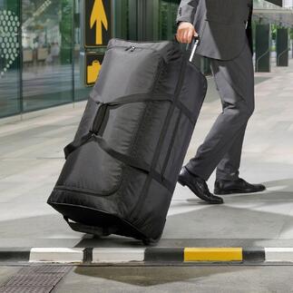 Schwarze Ultraleicht-XXL-Reisetasche wird von einem Mann im Anzug geschoben.