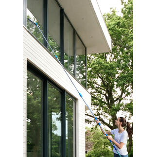 Frau reinigt Fenster mit Glas-Oberflächen-Cleaning-Set