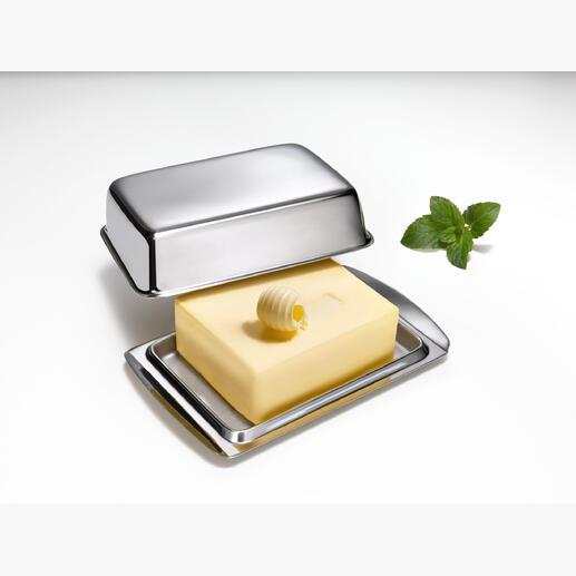 Edelstahl-Butterdose mit Deckel und Stück Butter auf einer weißen Unterlage