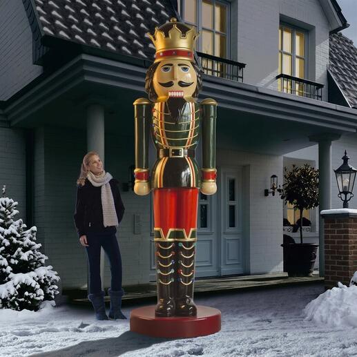 Lebensgroßer Nussknacker vor einem Haus, daneben steht eine Frau