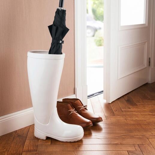 Stiefel als Schirmständer mit einem Regenschirm.