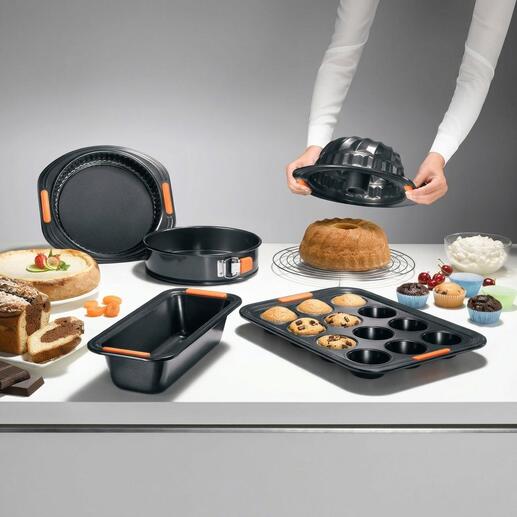 Le Creuset Haftfrei-Backformen auf einem Tisch mit Kuchen und Keksen.