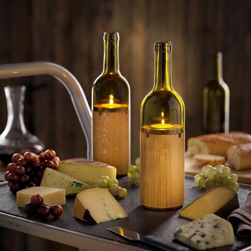 Zwei Weinlichter auf einem Tisch mit Käse und Trauben.