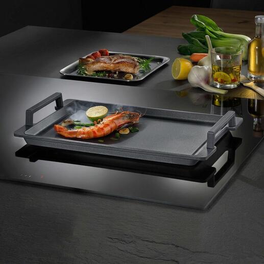 Teppanyaki-Platte mit Garnelen und Gemüse auf einem Kochfeld.