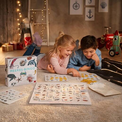 Kinder spielen Meeres-Bingo auf dem Boden mit Spielmaterial.
