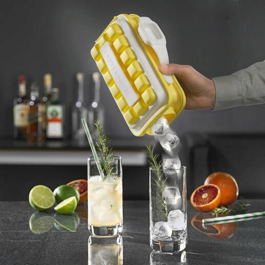 Hand hält Ice-Pop Eiswürfelform, Eiswürfel fließen in ein Glas mit Getränk.