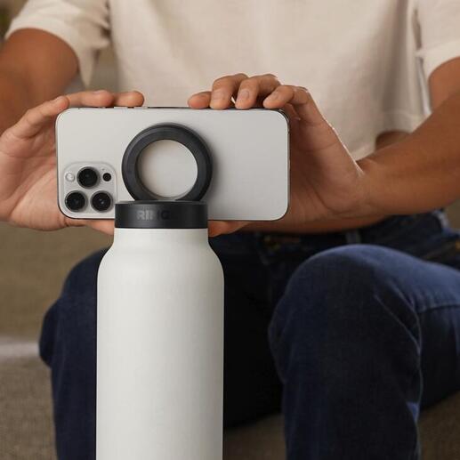 Person hält eine 2-in-1-Trinkflasche, während ein Smartphone darauf balanciert.