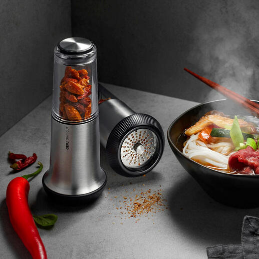 Chili-Schneider X-Plosion® neben einer Schüssel mit dampfendem Essen