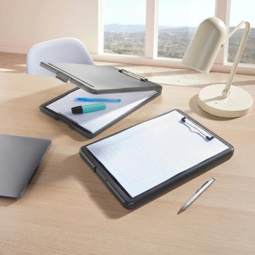 Zwei transparente Clipboard-Ordner auf einem Schreibtisch mit Stiften und Laptop.