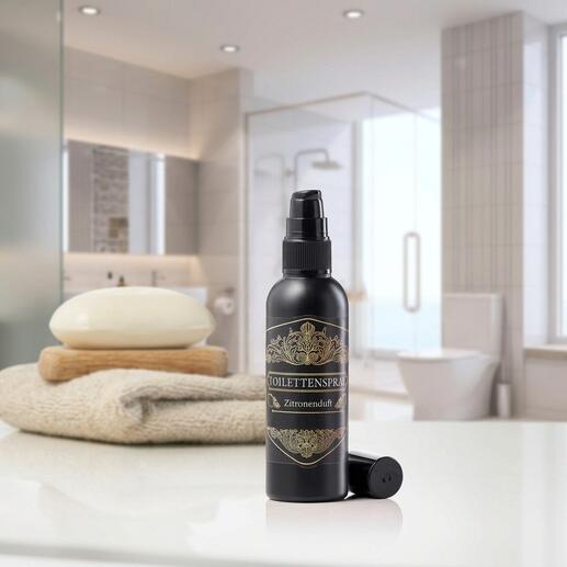 Zitronen-Duft Toilettenspray in schwarzer Flasche auf einem Badetuch.