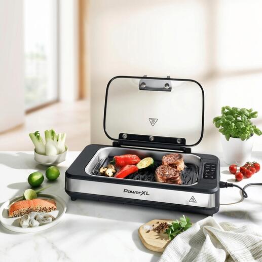 Tischgrill mit offenem Deckel und Gemüse und Fleisch darauf.