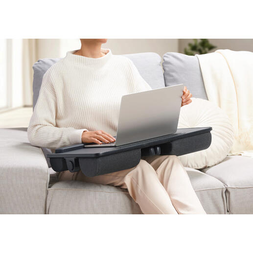 Person mit einem 2-in-1 Laptopkissen auf dem Schoß, das als Tisch dient.