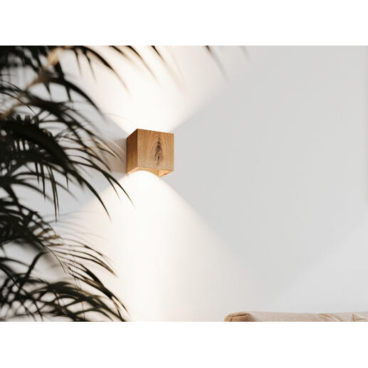 Wandleuchte Cubus, Eiche, an der Wand mit Pflanzen im Vordergrund