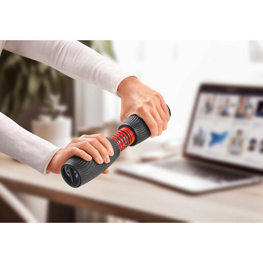 Person trainiert mit Handgelenk- und Unterarmtrainer an einem Tisch mit Laptop.