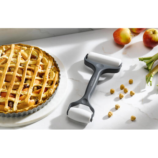 Doppel-Teigroller steht neben einem Apfelkuchen auf einem Küchentisch.
