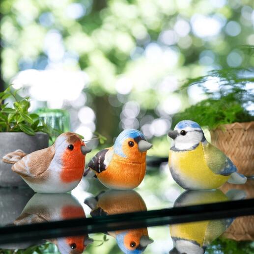 Drei dekorative Vogelfiguren in natürlichen Farben.