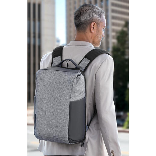 Anti-Diebstahl-Rucksack Die perfekte Kombination aus Sicherheit und Stil: der moderne Anti-Diebstahl-Rucksack. Mann mit grauem Anti-Diebstahl-Rucksack auf dem Rücken vor urbanem Hintergrund.
