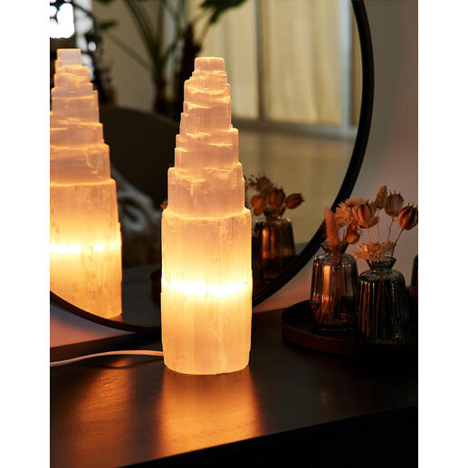 Selenit-Lampe leuchtet sanft auf einem Tisch.