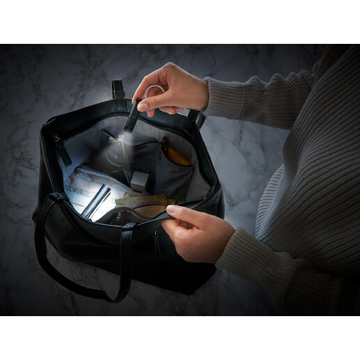 Zwei Hände halten eine smarte Mikro-Taschenlampe in einer Tasche