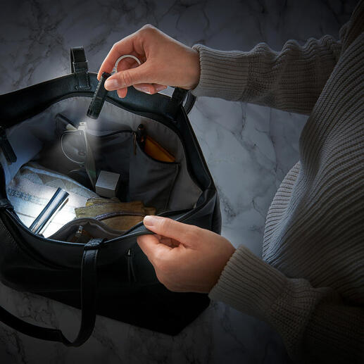 Zwei Hände halten eine smarte Mikro-Taschenlampe in einer Tasche