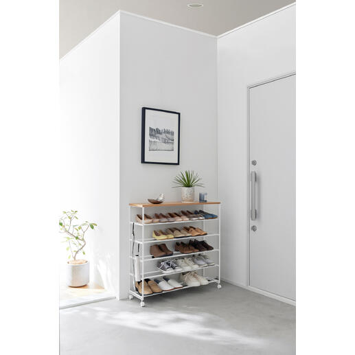 Rollbares Schuhregal in Schwarz mit mehreren Fächern für Schuhe, auf einem grauen Boden.