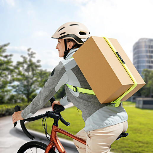 Mann auf Fahrrad mit Paketrucksack, der ein großes Paket transportiert.