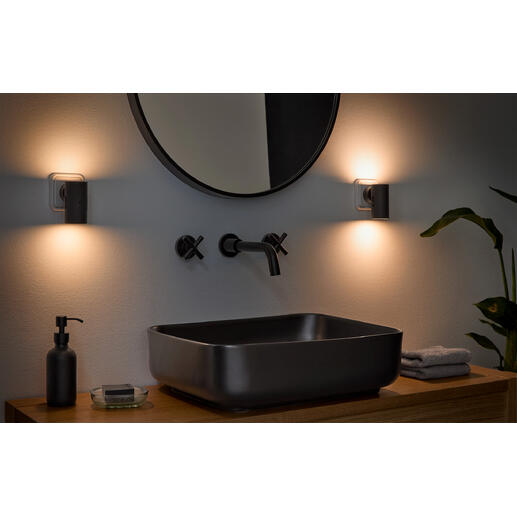 Dimmbare Wandleuchte in einem Badezimmerumfeld neben einem modernen Waschbecken.