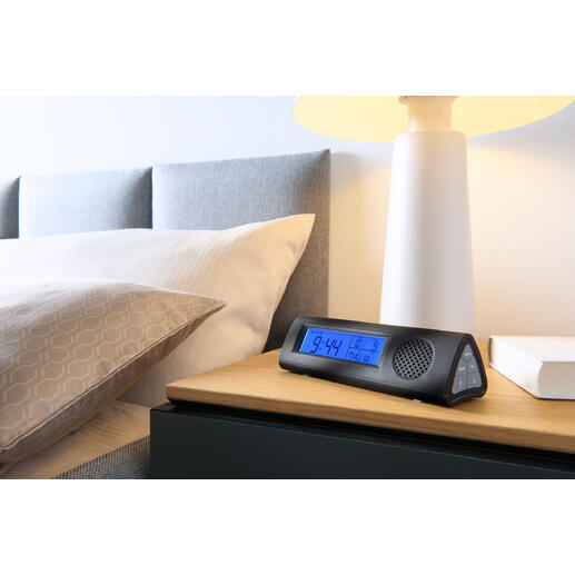 Radiowecker mit LED-Taschenlampe auf Nachttisch neben Bett