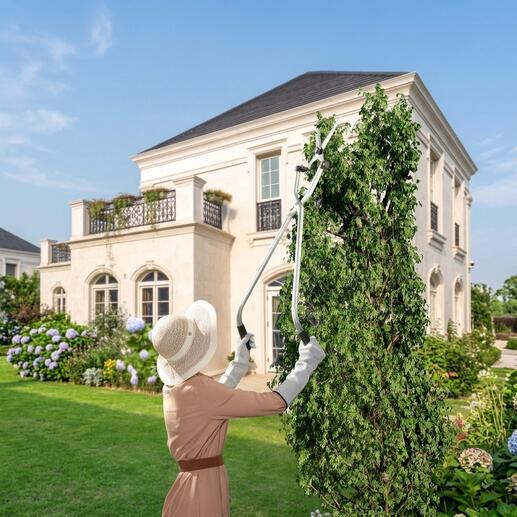 Frau schneidet mit einer Multiwinkel-Gartenschere hochgewachsene Pflanzen im Garten.