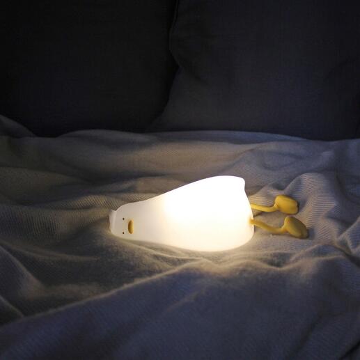 Müde Ente Nachtlicht leuchtet auf einem Bett.